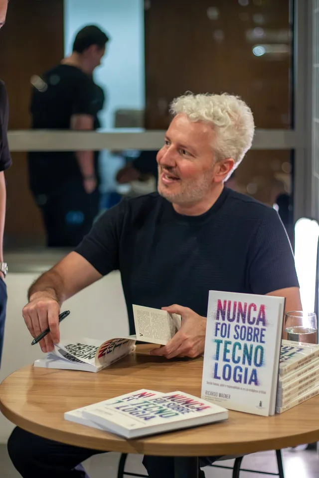 Ricardo Wagner segurando o livro Nunca Foi Sobre Tecnologia